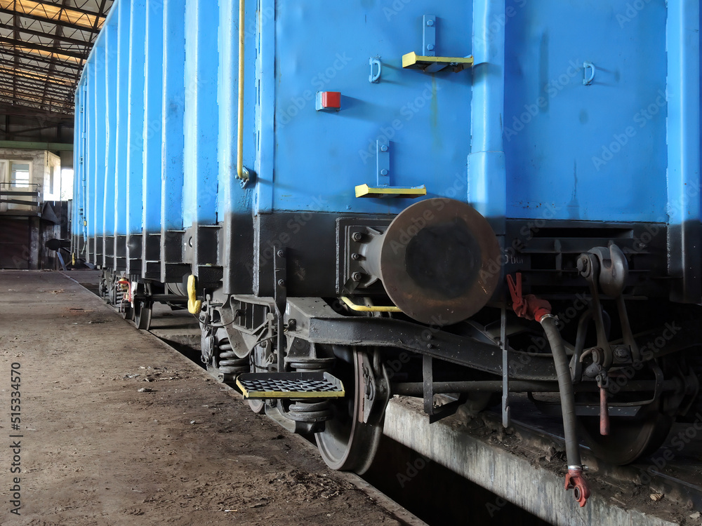 Blue wagon in an old workshop of wagons and railway locomotives. Place of repair and renovation for trains. Blue wagon in an old workshop of wagons and railway locomotives. Place of repair and renovation for trains.
