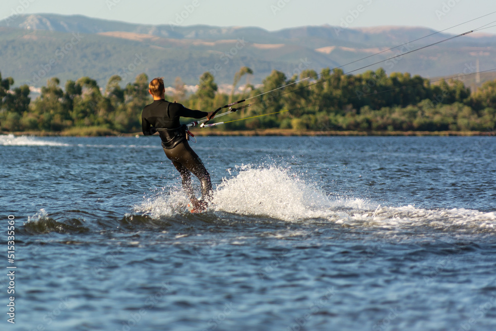 Expert Kitesurfer Planing with Sea Watrer Splashes during Golden Hour on Blurred Background Expert Kitesurfer Planing with Sea Watrer Splashes during Golden Hour on Blurred Background
