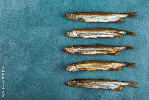A few smoked capelin on a blue background. photo