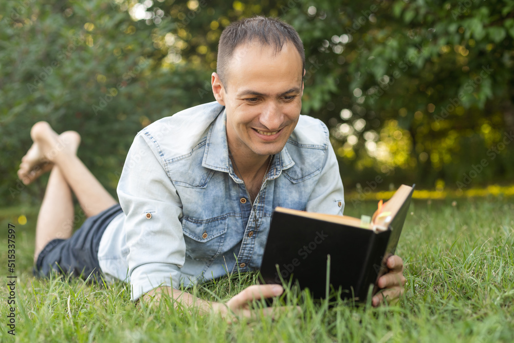 Man reading a book on the grass Man reading a book on the grass