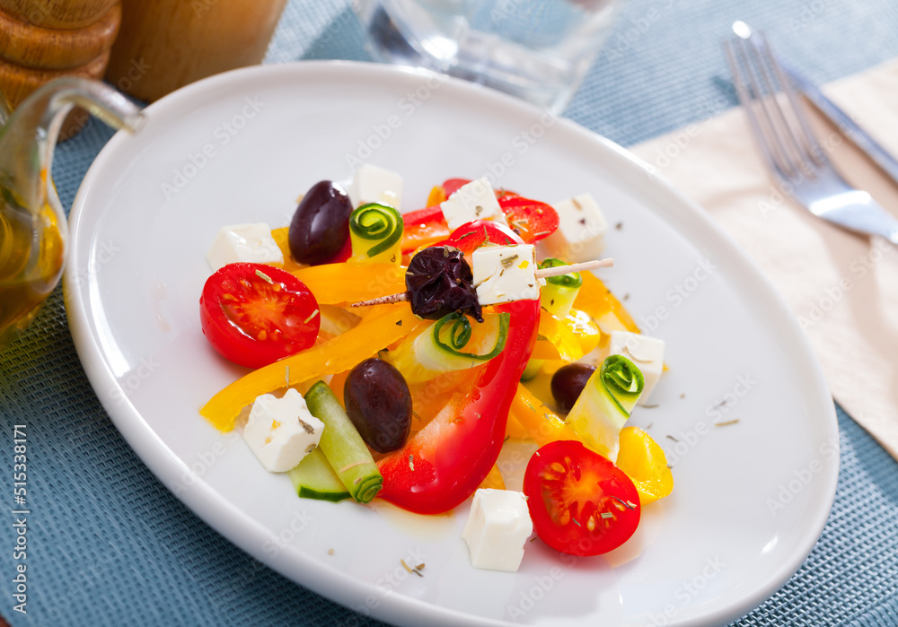 Appetizing Greek salad with feta cheese, fresh vegetables and black olives