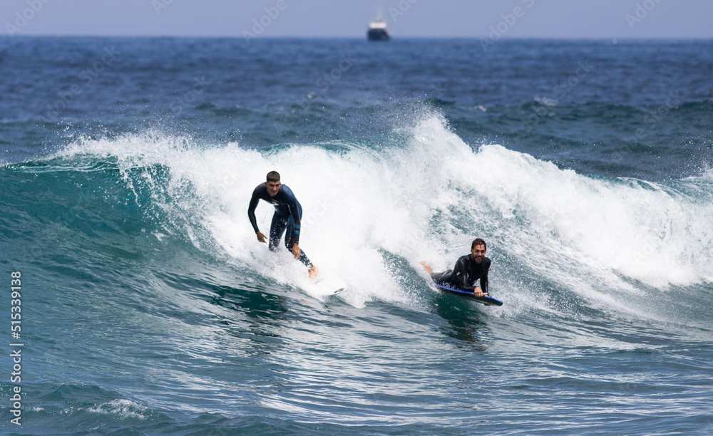PUERTO DE SANTIAGO, TENERIFE - JUNE 2022: surfer riding the waves in Tenerife PUERTO DE SANTIAGO, TENERIFE - JUNE 2022: surfer riding the waves in Tenerife