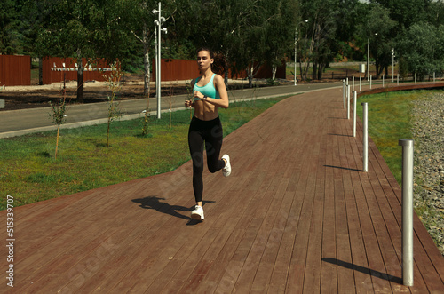 Young happy woman in sportswear runs in the park. Morning running. Healthy lifestyle © Alexandr