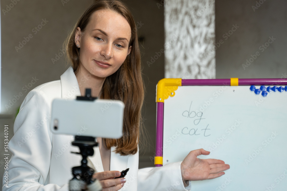 English teacher online at home. Portrait of a woman writing on a blackboard in class. English teacher online at home. Portrait of a woman writing on a blackboard in class.