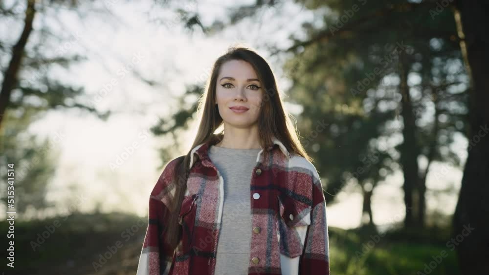 Portrait of a beautiful young woman, in a casual shirt. Brunette with long hair in a pine forest. Portrait of a beautiful young woman, in a casual shirt. Brunette with long hair in a pine forest.