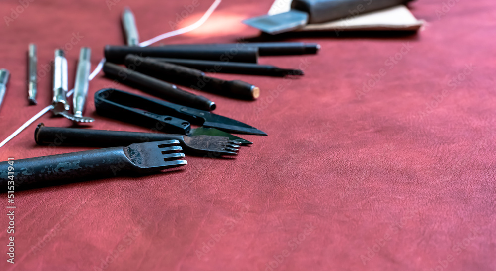 set of leather making tools on red genuine leather with copy space set of leather making tools on red genuine leather with copy space