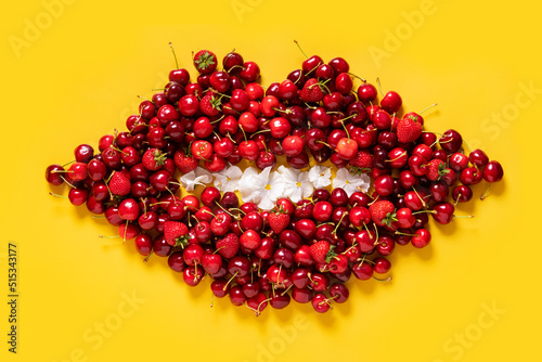 Cherry and strawberry red fruits pattern in a shape of a mouth on bright yellow background