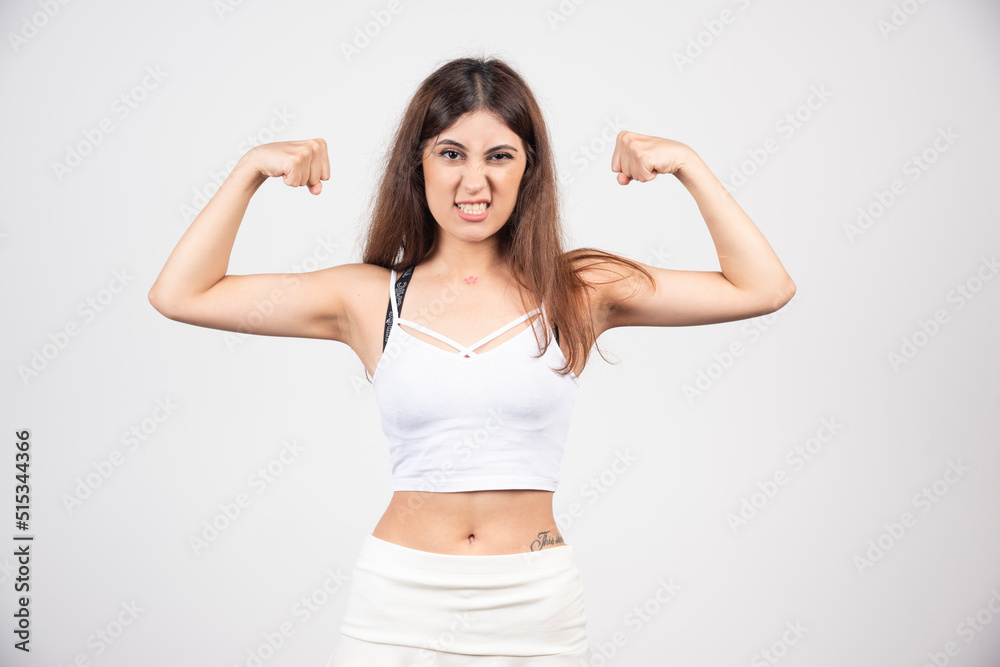 Picture of young sporty woman showing her biceps