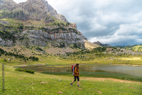 A woman with her son in the backpack in the Ibon de Piedrafita, Tena valley in the Pyrenees, Huesca