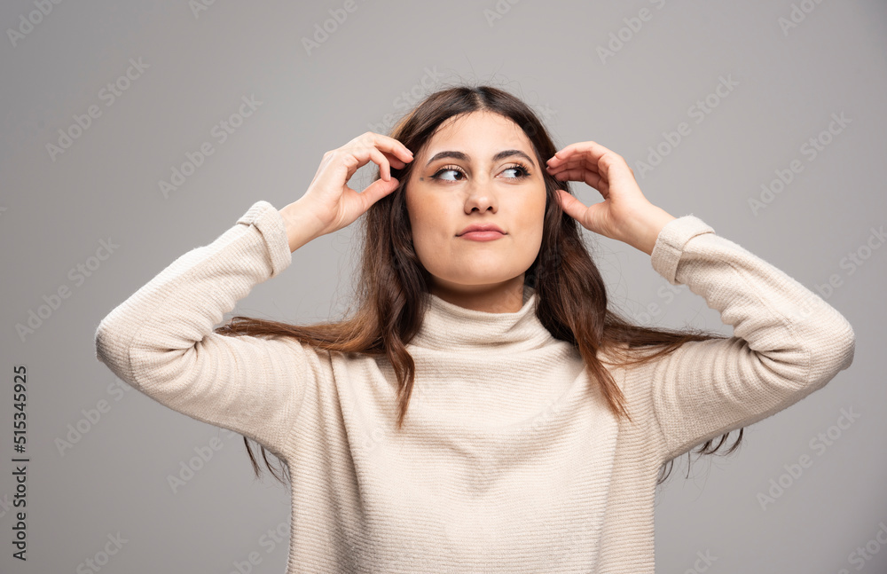 Portrait of a young woman posing on a gray wall Portrait of a young woman posing on a gray wall