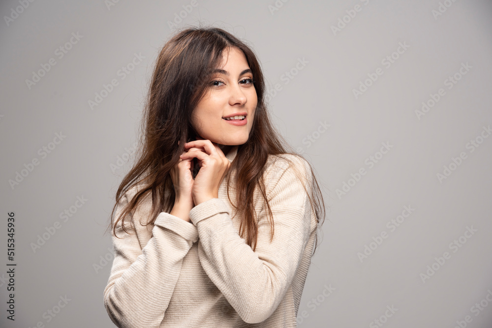 Portrait of a young woman posing on a gray wall Portrait of a young woman posing on a gray wall