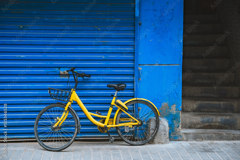 Yellow bicycle parked by the blue wall Yellow bicycle parked by the blue wall