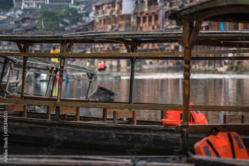 Old wooden boats moored on Tuo river shore in Fenghuang
