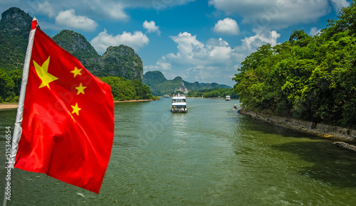 Red Chinese national flag on a boat sailing on Li River