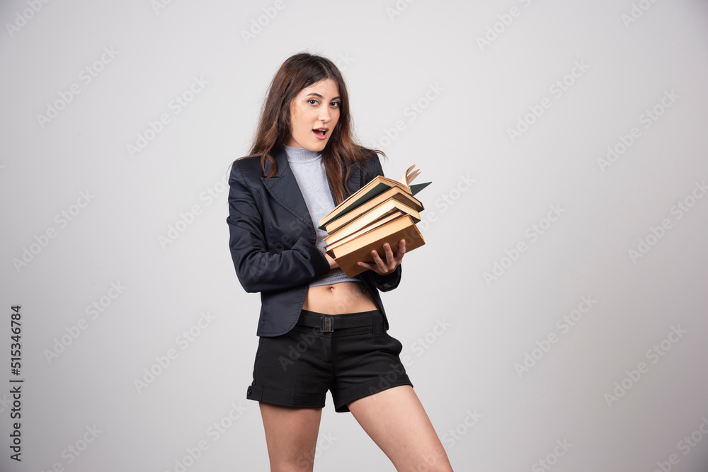Portrait of lovely business woman holding a stack of books Portrait of lovely business woman holding a stack of books