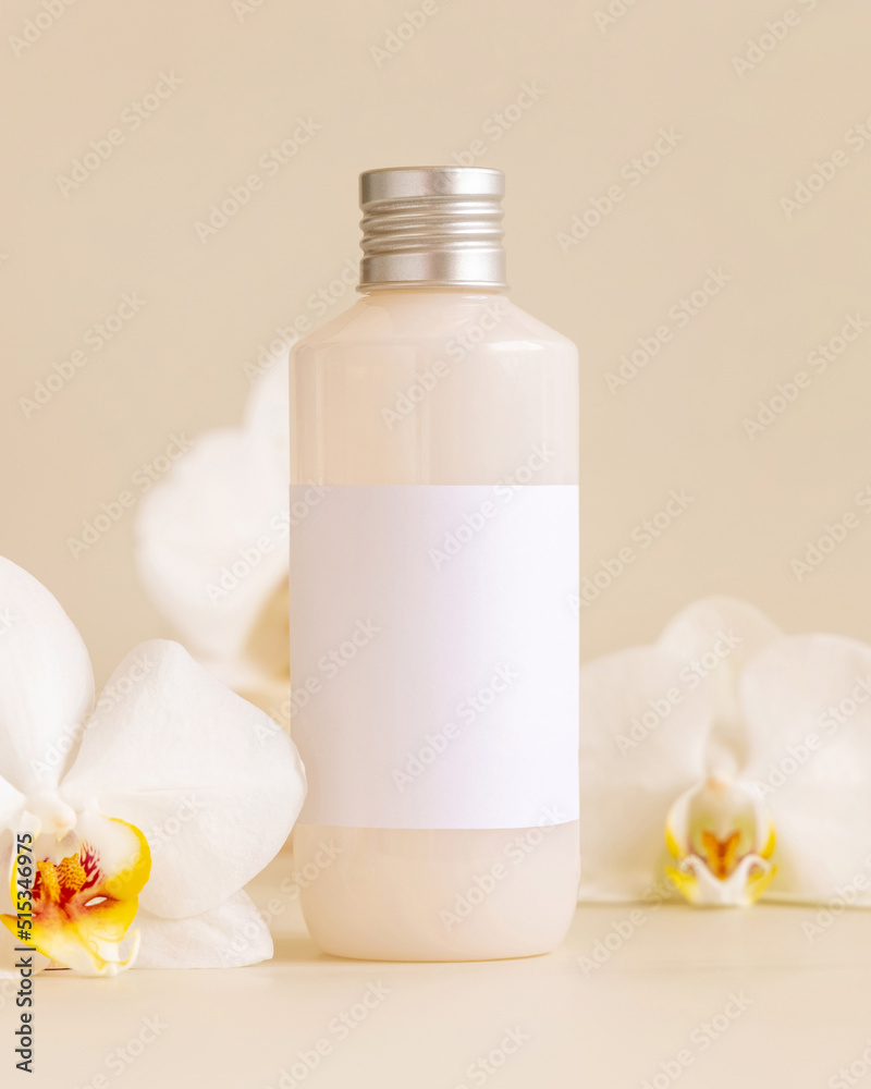 Cosmetic bottle with blank label near white orchid flowers on light yellow, Mockup