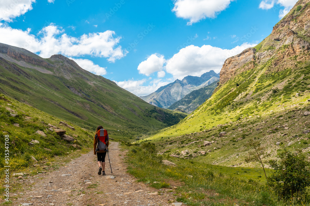 A young man in the mountains walking alone in the Ripera valley in summer, Pyrenees