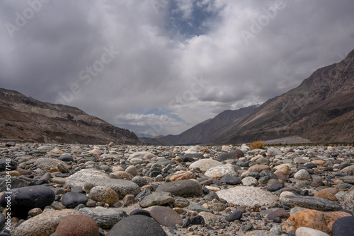 landscape with sky, clouds and stones in riverbed