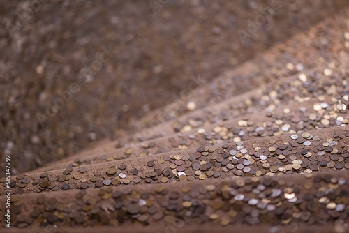 Obraz na płótnie Vertical shot of shiny coins thrown on the stairsfor good luck w salonie