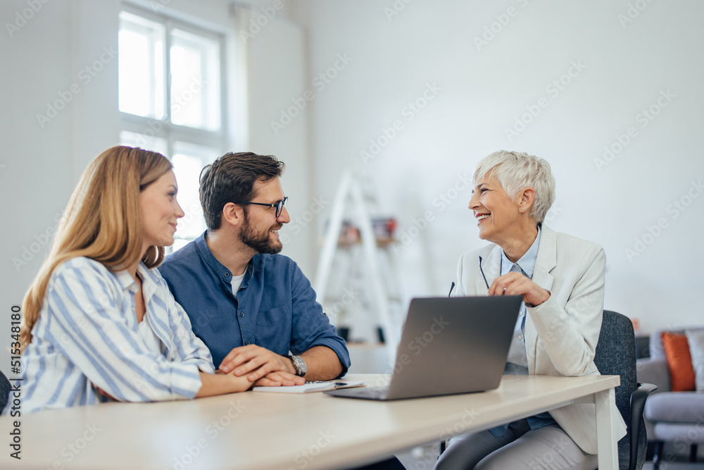 A smiling couple having a conversation with the insurance agent, looking at each other. A smiling couple having a conversation with the insurance agent, looking at each other.