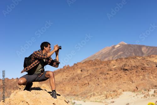 Young man taking pictures on a road trip. Man making memories on the mountain..