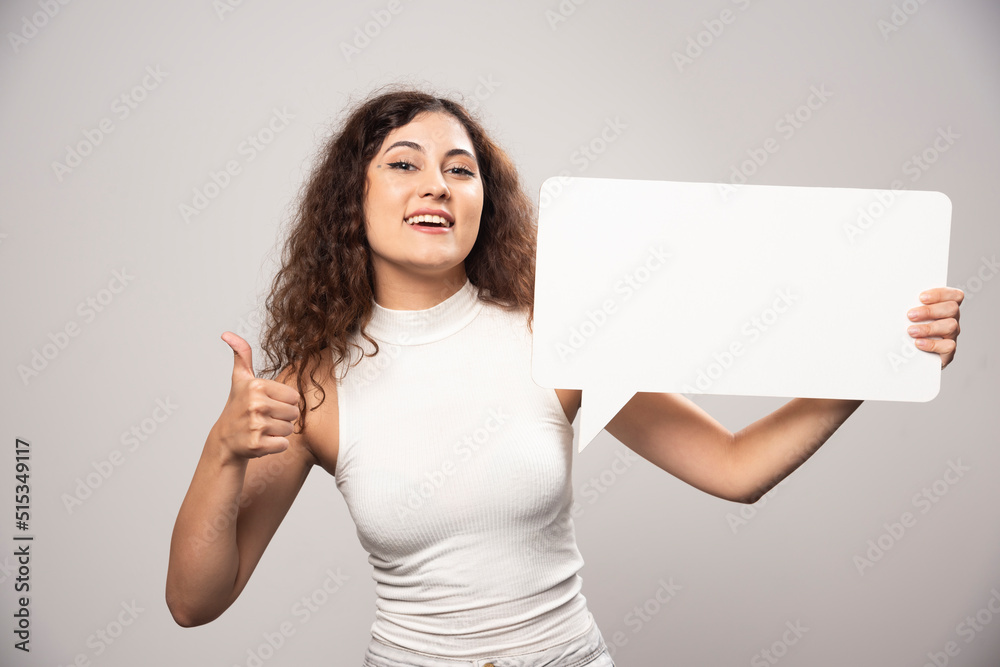 Young woman holding empty blank white speech poster Young woman holding empty blank white speech poster