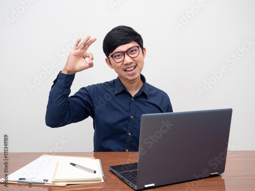 Young business man hand ok sit at workplace white background