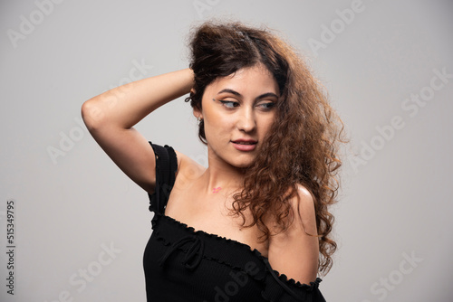 Young woman posing in black blouse with curly hair