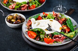 Burrata, Italian fresh cheese made from cream and milk of buffalo or cow. Burrata salad with tomatoes and salad mix. Healthy eating concept. Keto diet salad.