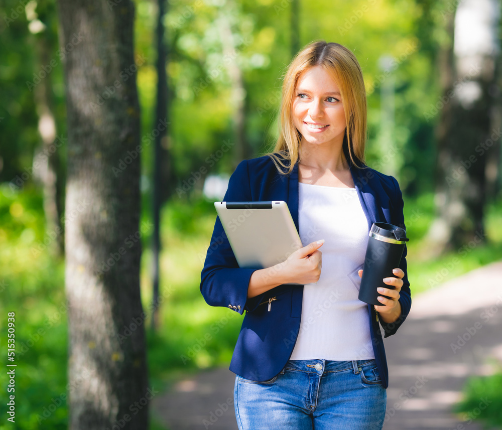 Young smiling beautiful woman in park with tablet gadget and wireless headphones enjoying - green energy concept, remote work Young smiling beautiful woman in park with tablet gadget and wireless headphones enjoying - green energy concept, remote work