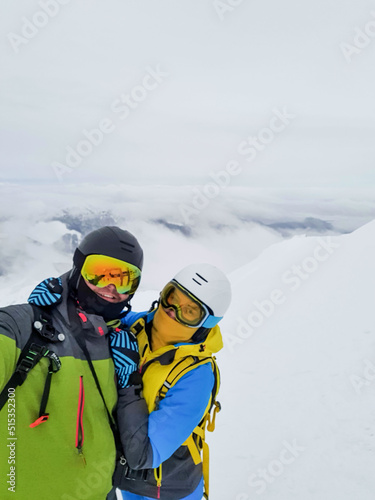 couple skier and snowboarder taking selfie at the mountain top
