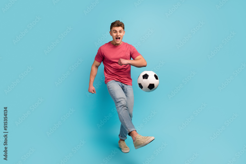 Full size photo of young man play football kick ball team game championship isolated over blue color background