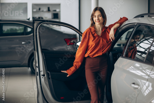 Woman choosing a car in a car showroom