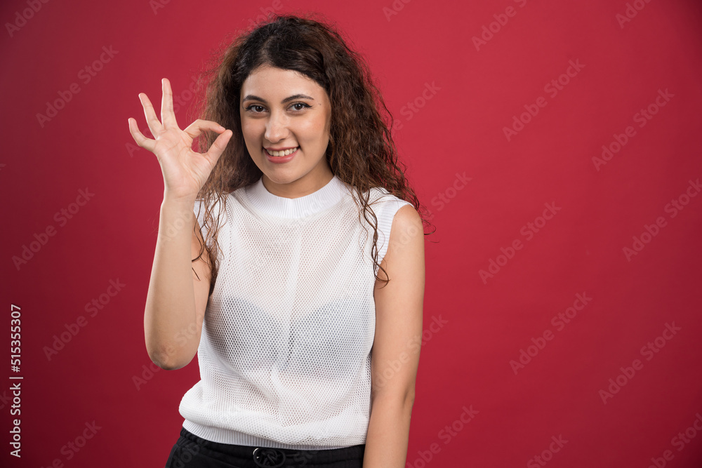 Woman with ok gesture on red background Woman with ok gesture on red background
