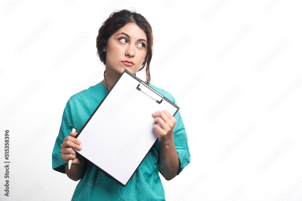 Female doctor showing empty clipboard with pen and stethoscope on white background Female doctor showing empty clipboard with pen and stethoscope on white background