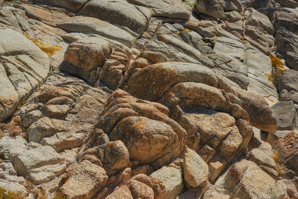 Closeup of large rocks or boulders near the mountains. Large multicolored granites. Details of big grey stone structures with orange particles shining in the sunlight. Sandstones with rough textures Closeup of large rocks or boulders near the mountains. Large multicolored granites. Details of big grey stone structures with orange particles shining in the sunlight. Sandstones with rough textures