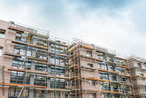Tall building under construction with scaffolds.Scaffolding on multi storey building facade during renovation.