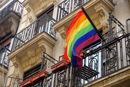 Facade of the house Chueca district in the city of Madrid with a rainbow flag representing homosexual  LGTBI rights. Rainbow flags on the balconies of a house in the Chueca district in Madrid, Spain. photo