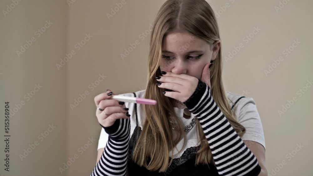 Teenage girl looks fearfully at a pregnancy test. Teenage girl looks fearfully at a pregnancy test.