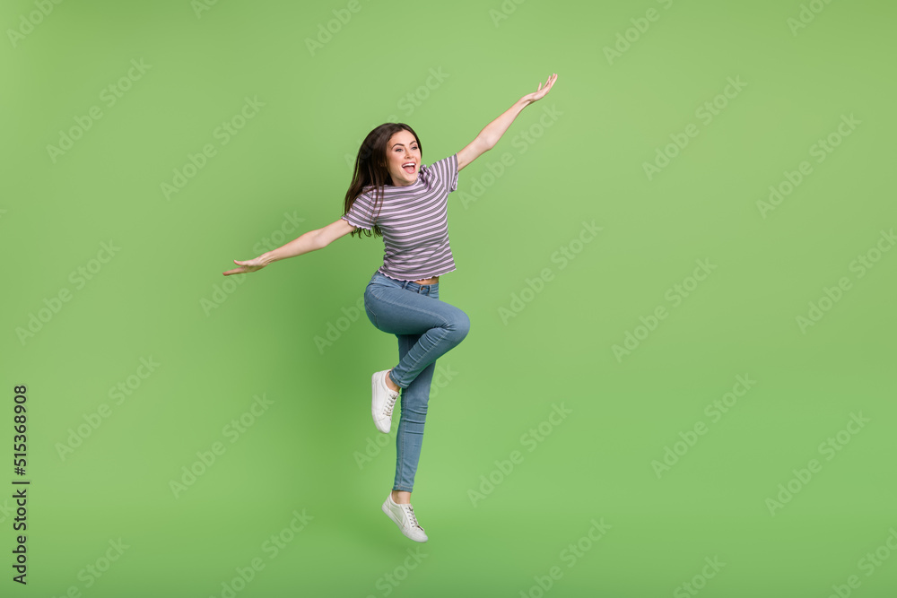 Full length photo of overjoyed glad person raise arms enjoy free time isolated on green color background