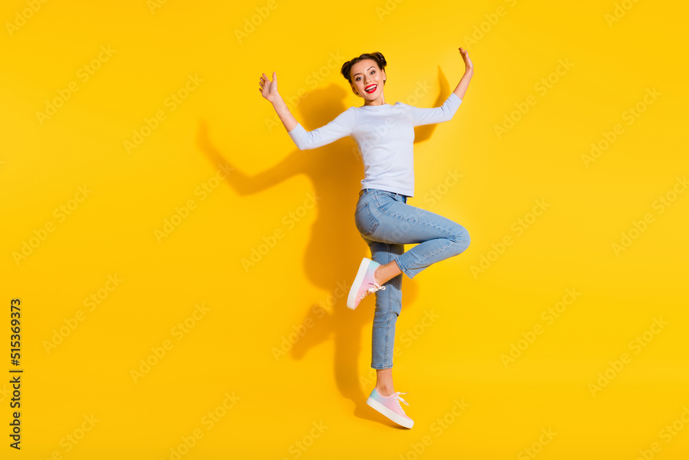 Full length photo of sweet excited lady wear long sleeve jumping high empty space isolated yellow color background