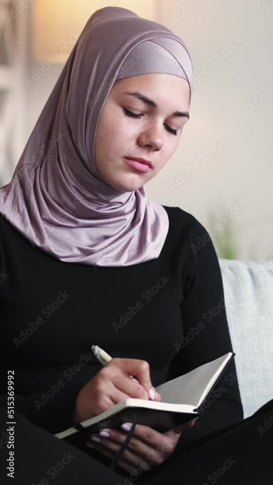 Vertical video. Writing hobby. Creative home leisure. Personal journal. Relaxed inspired pensive woman thinking taking notes in diary on couch. Vertical video. Writing hobby. Creative home leisure. Personal journal. Relaxed inspired pensive woman thinking taking notes in diary on couch.