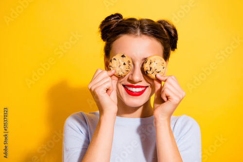 Photo of sweet pretty lady wear long sleeve holding two biscuits close eyes isolated yellow color background