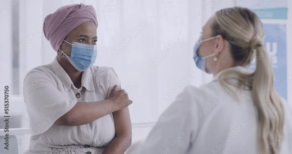 Doctor injecting a patient with the covid19 vaccine at hospital. Two woman wearing masks and protecting themselves from the spread of disease. Nurse talking to a nervous patient after receiving shot Doctor injecting a patient with the covid19 vaccine at hospital. Two woman wearing masks and protecting themselves from the spread of disease. Nurse talking to a nervous patient after receiving shot
