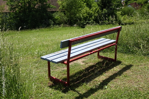 Blue and red wood and metal resting bench in Northern Palatinate (Pfälzer Bergland) landscape, sunny spring day, concept: rest, relaxation, outdoor (horizontal), Wolfstein, RLP, Germany