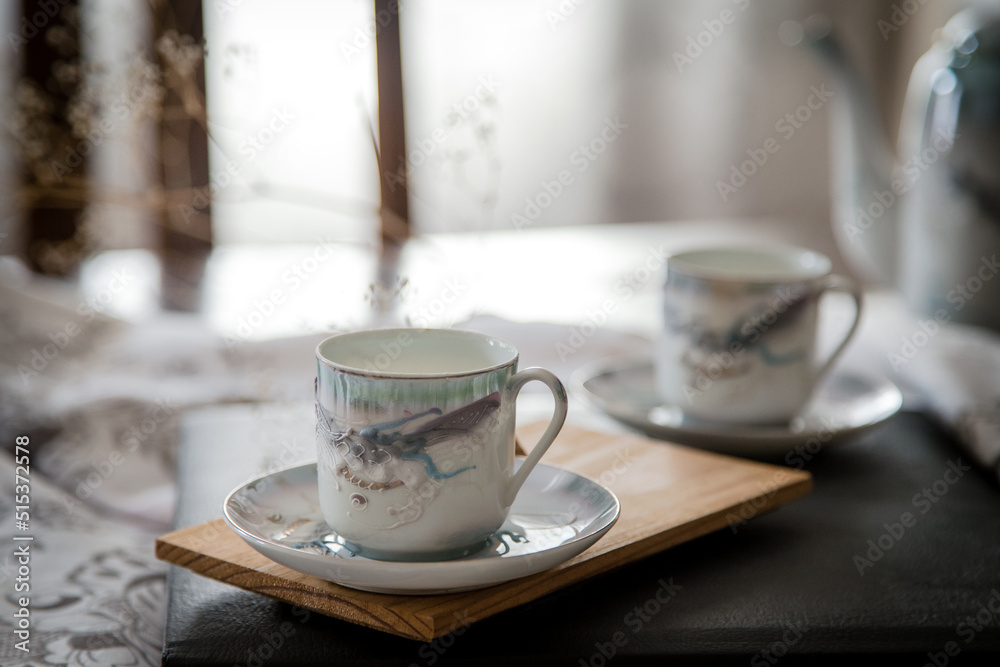 Fototapeta premium Breakfast or coffee break in a rustic, intimate and cozy atmosphere. Cups of coffee or tea crafted on an ornate table.