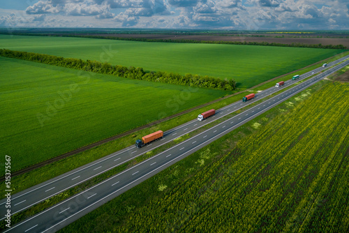 convoys with cargo. truck on the highway. asphalt road among green fields and beautiful clouds. cargo delivery and transportation concept