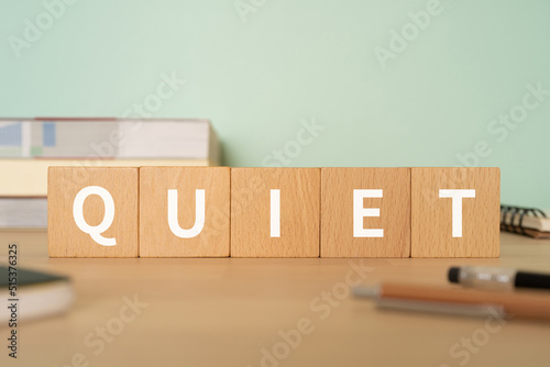 「QUIET」と書かれたブロックが置かれたデスク 