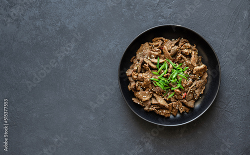 bulgogi on a black background, korean beef dish, asian food, top view, copy space photo