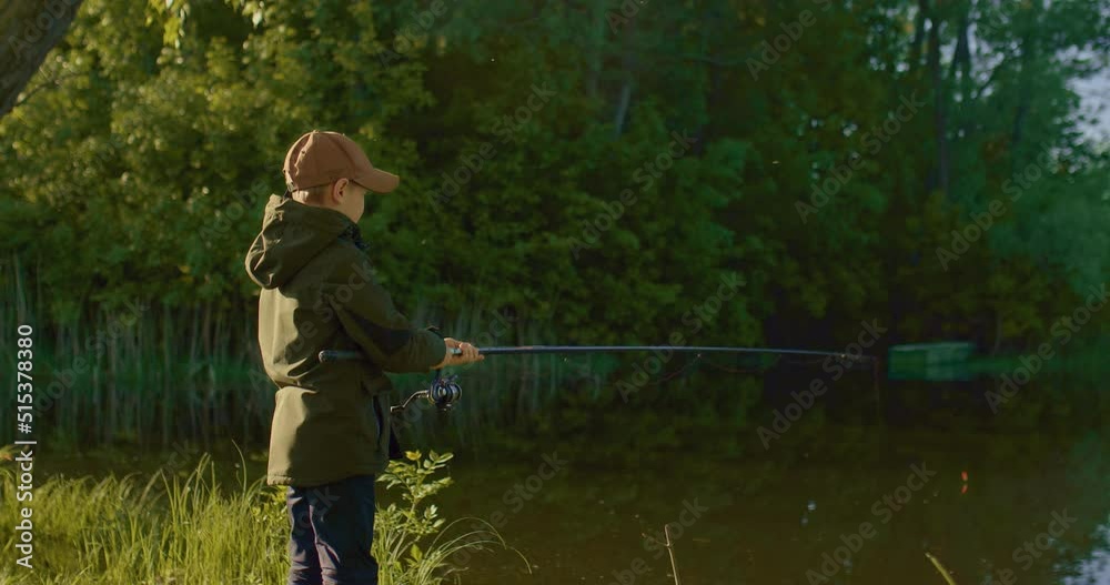 little boy is waiting for bite on coast of pond, and pulling small fish by rod, 4K, Prores little boy is waiting for bite on coast of pond, and pulling small fish by rod, 4K, Prores